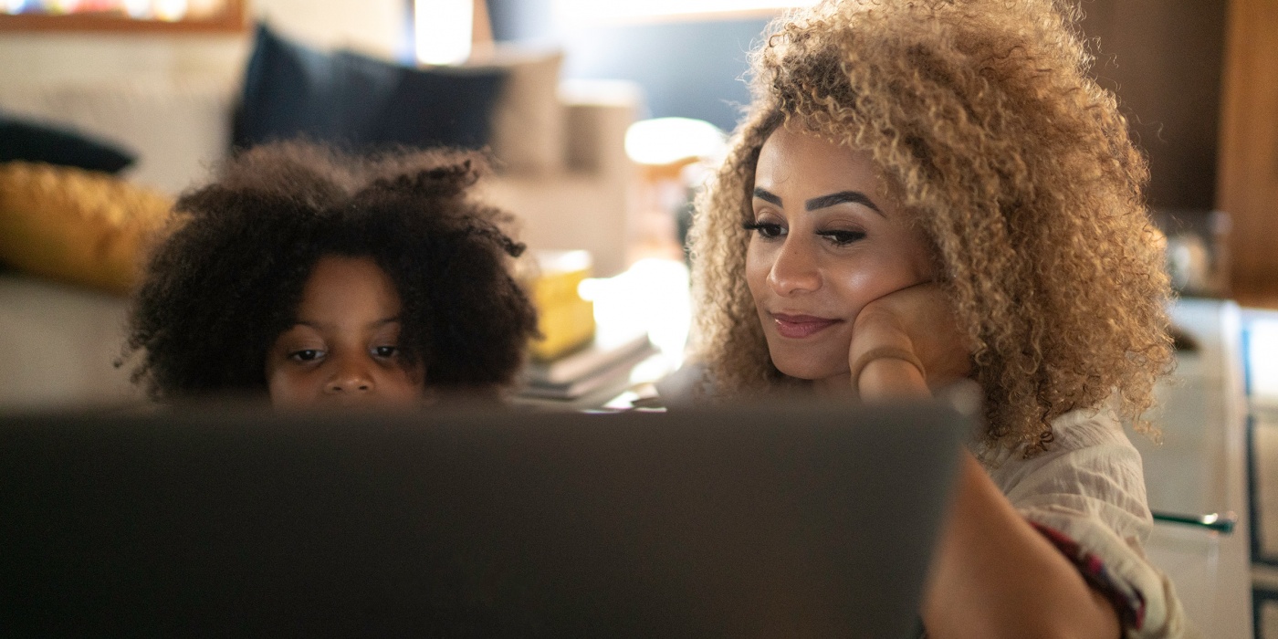 African American mother and daughter reading laptop